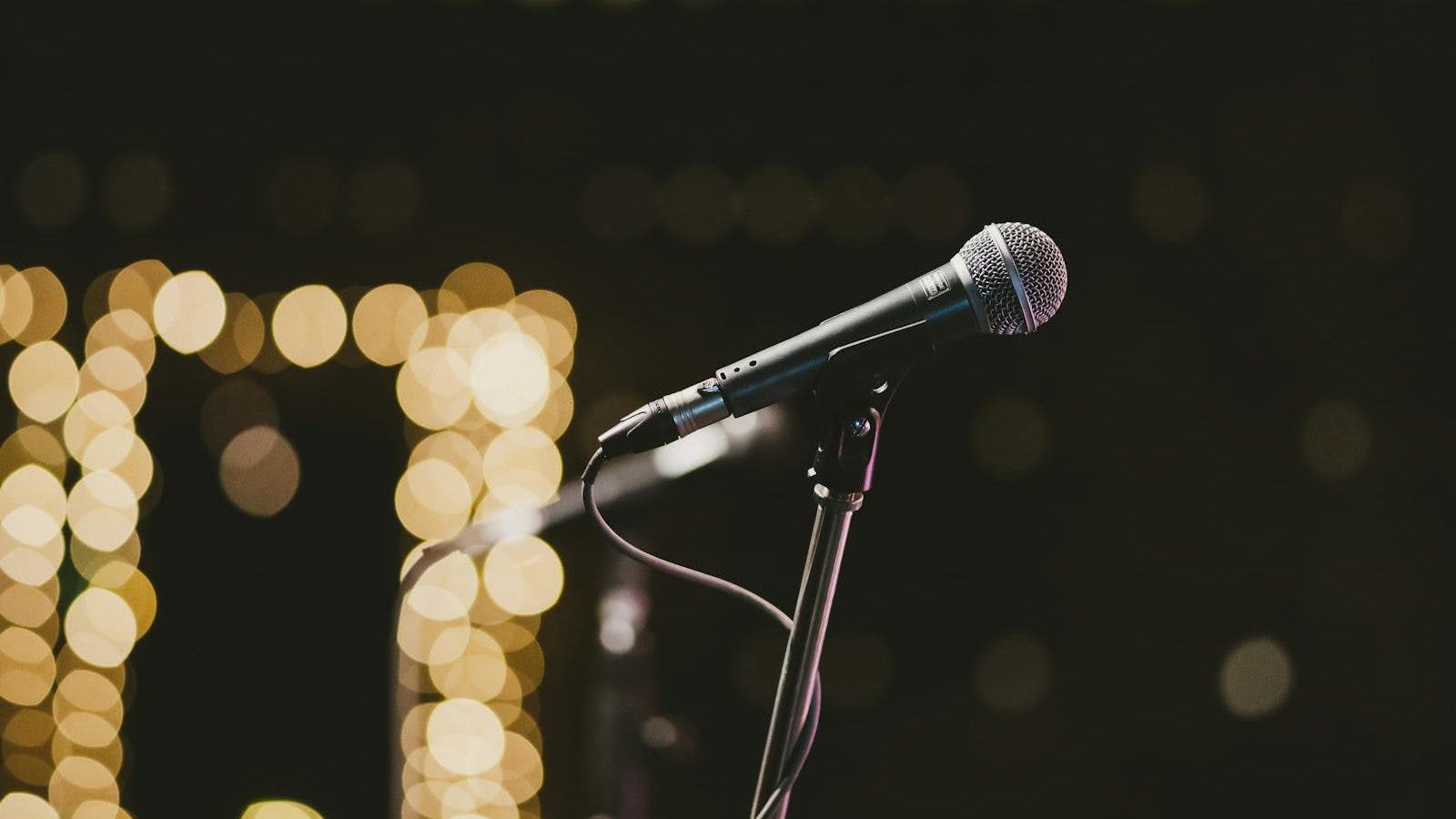 Selective Focus Photography Of Microphone On Microphone Stand