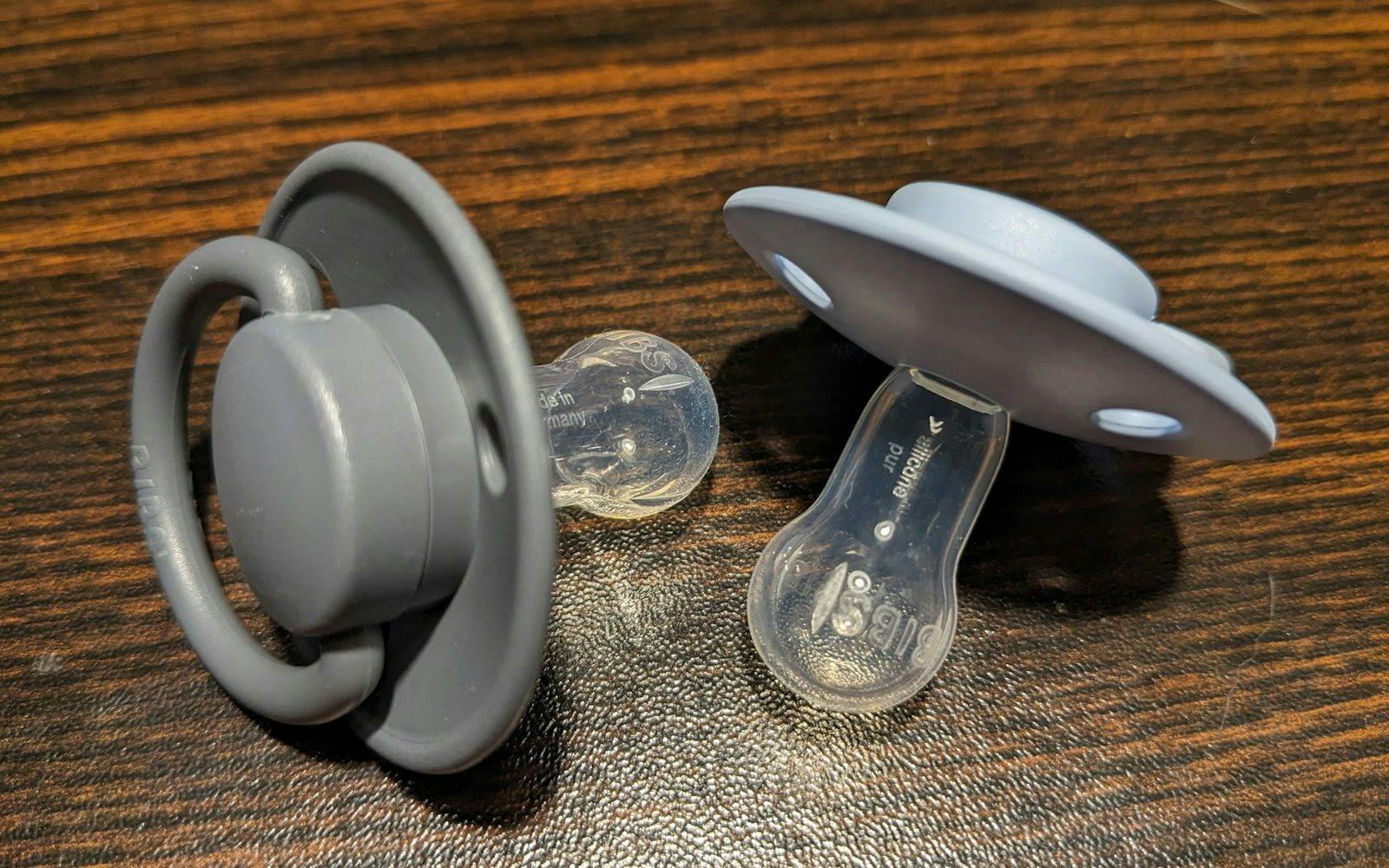 a pair of pacifiers sitting on top of a wooden table