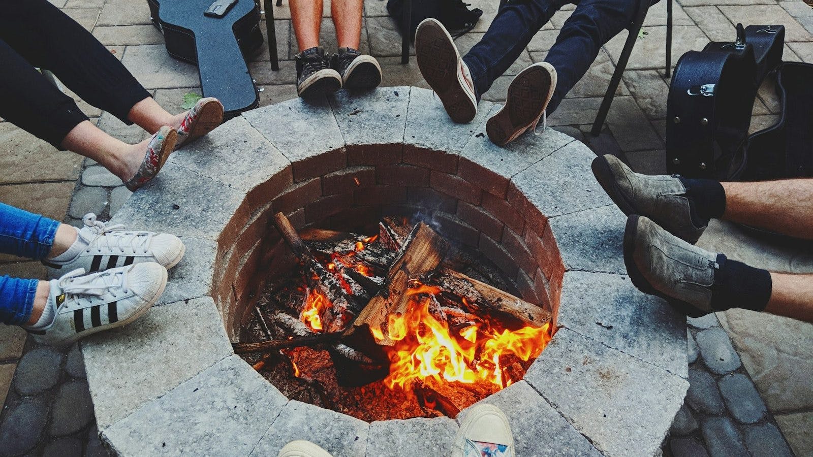 people's feet on top of firepit