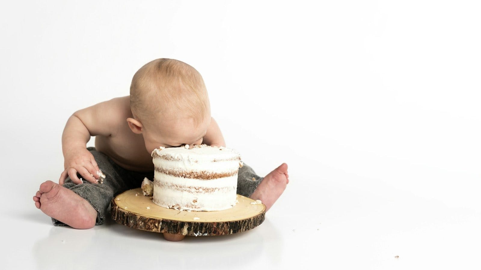 kid sitting beside round cake close-up photography