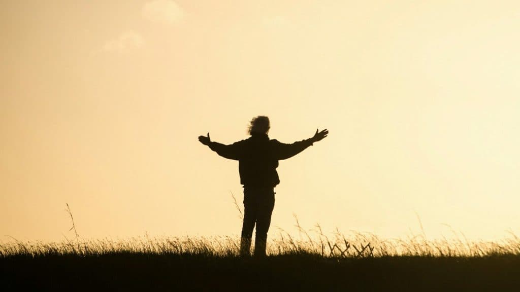 silhouette of person spreading hands