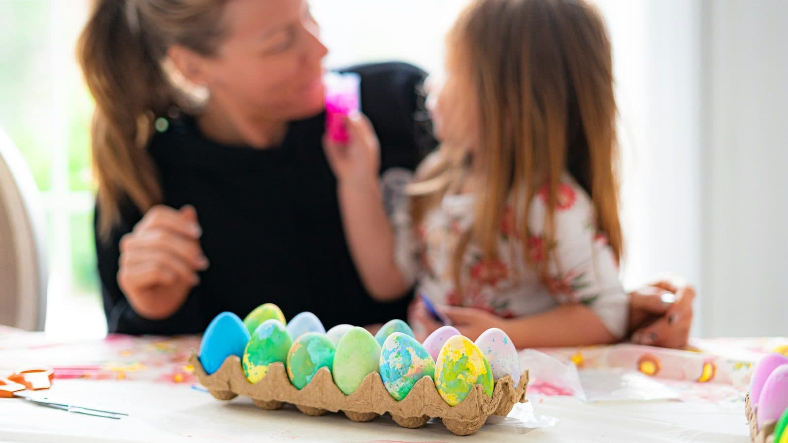 a woman and a little girl sitting at a table