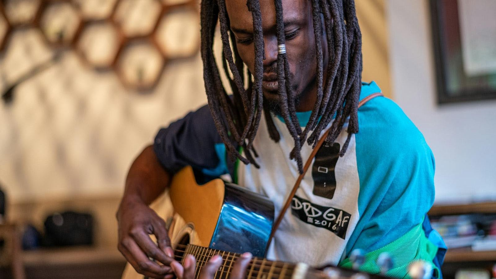 Focused black man playing guitar in studio