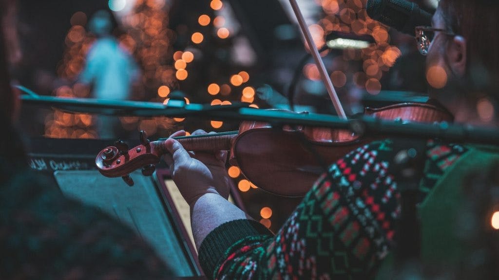selective focus photography of woman playing violin