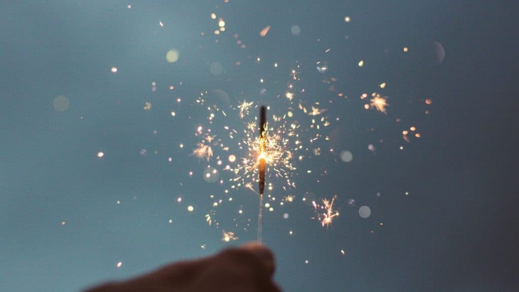 person holding lighted sparklers