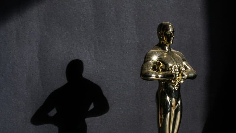 a golden statue of a man standing next to a black wall