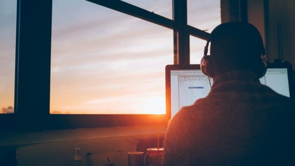 man sitting facing monitor