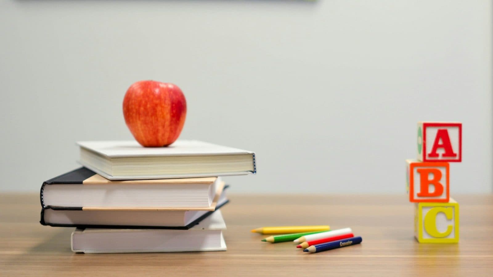 red apple fruit on four pyle books