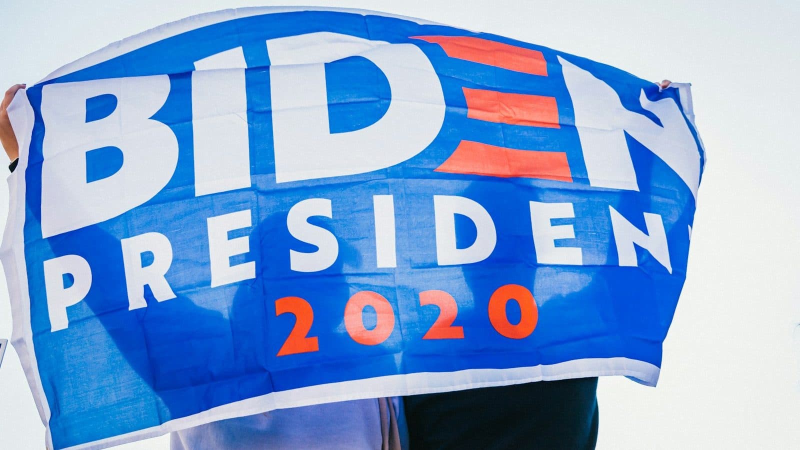 person in brown pants standing near blue and white big big big rock signage
