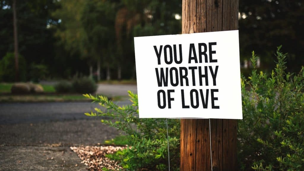 you are worthy of love sign beside tree and road