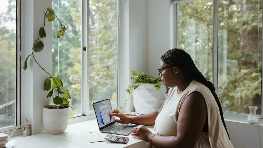 a woman sitting at a table with a laptop